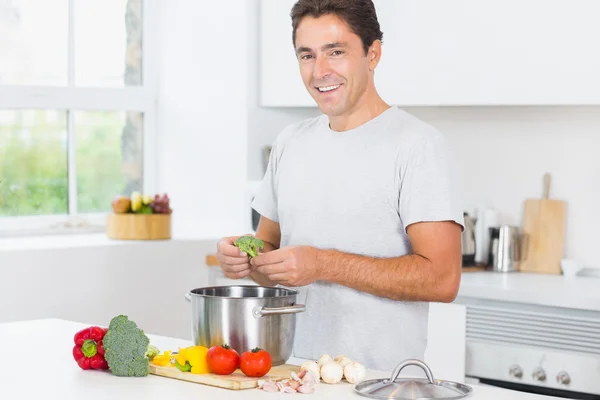 Un homme souriant prépare le dîner — Photo