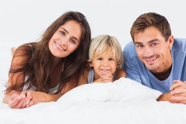 Familie liegt zusammen auf einem Bett — Stockfoto