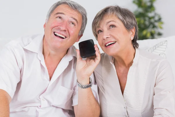 Old couple listening to a smartphone — Stock Photo, Image