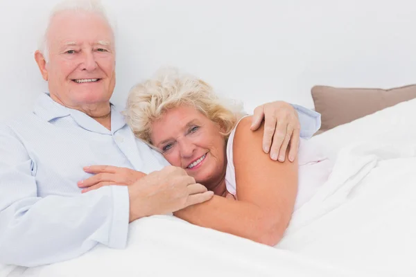 Fröhliches Paar auf dem Bett liegend — Stockfoto
