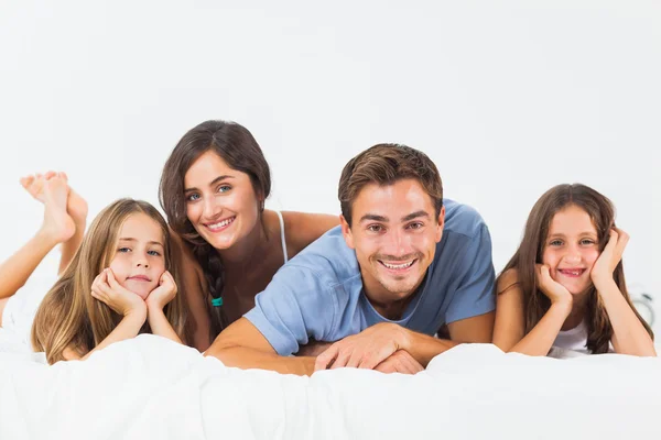 Niedliche Familie liegt zusammen auf einem Bett — Stockfoto