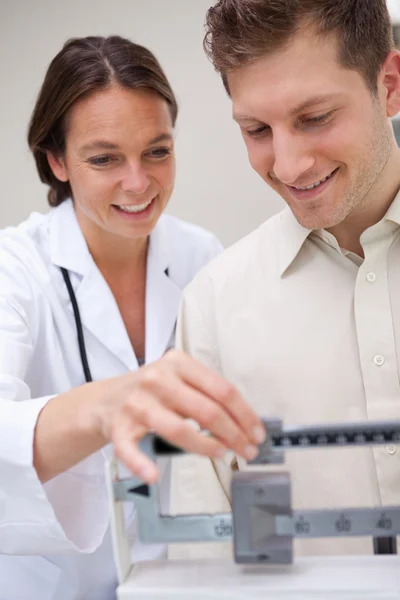 Doctor helping patient with adjusting scale — Stock Photo, Image