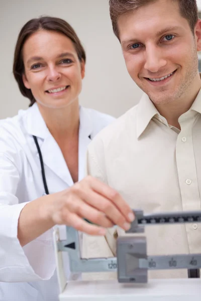 Médico midiendo pacientes peso —  Fotos de Stock