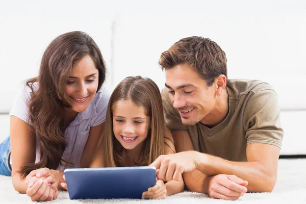 Familie liggend op een tapijt met Tablet PC — Stockfoto
