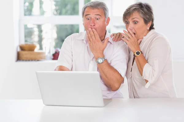 Vecchia coppia sorpreso di fronte a un computer portatile — Foto Stock