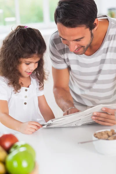 Папа и дочь читают газету — стоковое фото