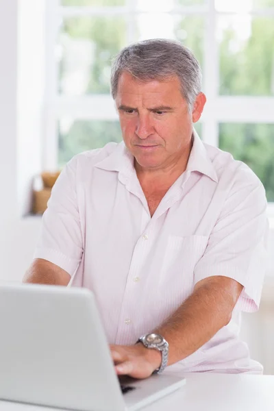 Old man using laptop seriously — Stock Photo, Image