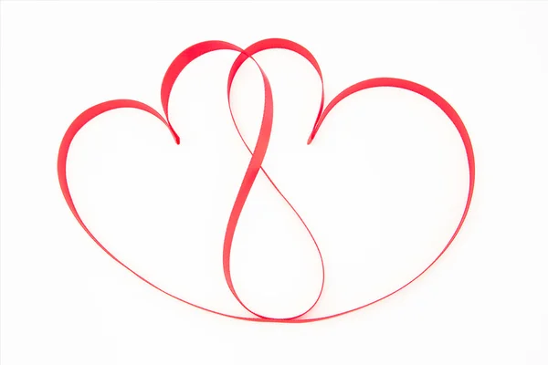 Pink ribbon shaped into intertwining hearts — Stock Photo, Image