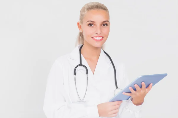 Улыбающийся молодой врач с планшетом — стоковое фото