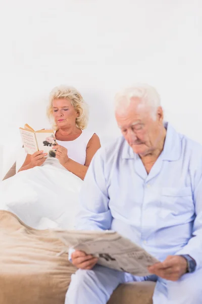 在床上阅读的老年夫妇 — 图库照片