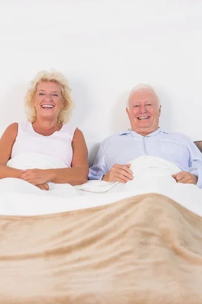 Aged couple lying on the bed — Stock Photo, Image