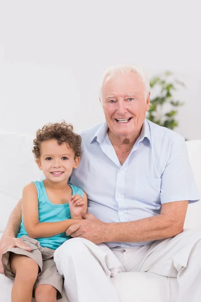 Happy grandfather and grandson sitting on the sofa — Stock Photo, Image