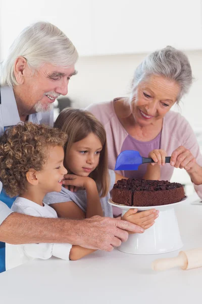 Children icing a cake in the kitchen — Stock Photo, Image