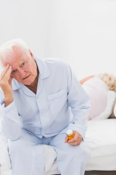 Elderly man suffering while woman sleeping on the bed — Stock Photo, Image