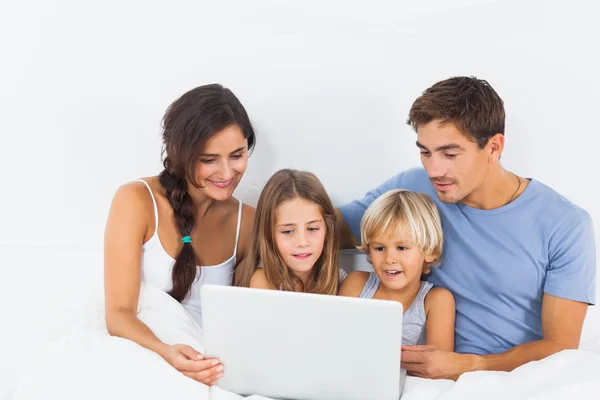 Famille assise avec un ordinateur portable — Photo