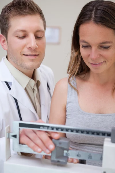 Doctor helping patient to adjust scale — Stock Photo, Image