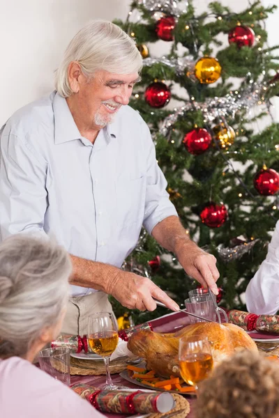 Grandfather carving turkey at christmas — Stock Photo, Image