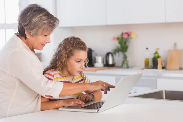 Mormor och barn tittar på laptop — Stockfoto