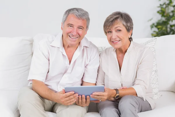 Old couple looking camera with tablet pc — Stock Photo, Image