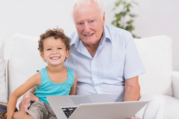 Grootvader en kleinzoon met een laptop — Stockfoto