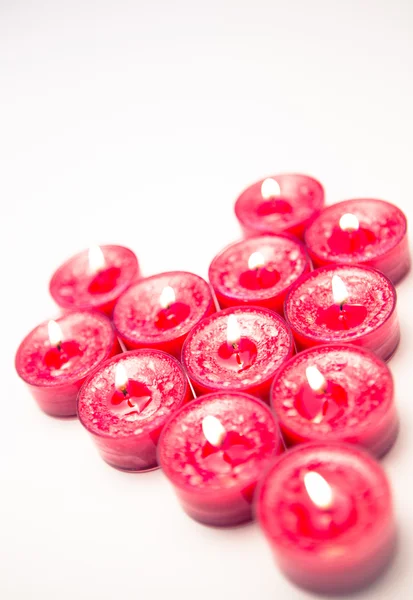 Lit pink candles in heart shape — Stock Photo, Image