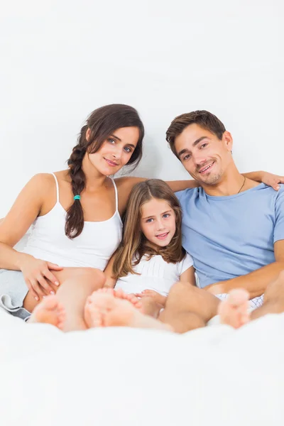 Šťastná rodina sedí na posteli — Stock fotografie