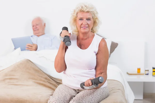 Mujer mayor haciendo ejercicio con pesas en las manos — Foto de Stock