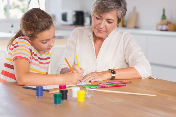 Petite fille dessin avec sa grand-mère concentré — Photo