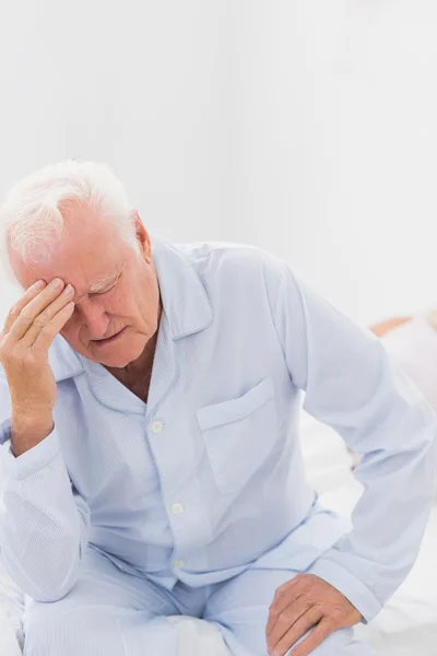 Hombre anciano que sufre mientras la mujer duerme — Foto de Stock