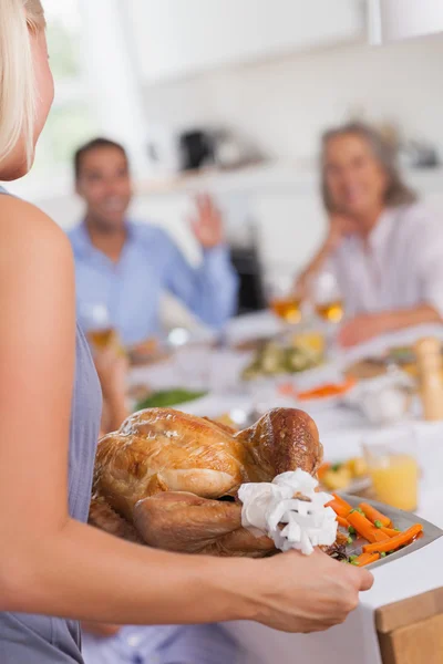 Woman bringing the turkey to the dinner table — Stock Photo, Image