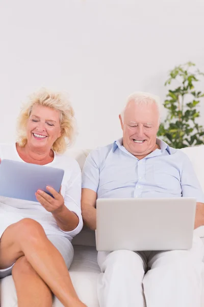 Casal velho usando um laptop e o tablet — Fotografia de Stock