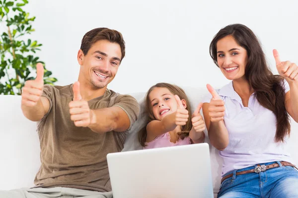 Familjen ger tummen upp med den bärbara datorn — Stockfoto