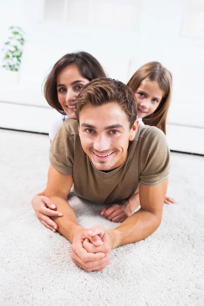 Familia acostada en una alfombra posando — Foto de Stock
