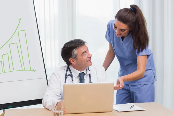 Arzt und Krankenschwester diskutieren am Laptop — Stockfoto