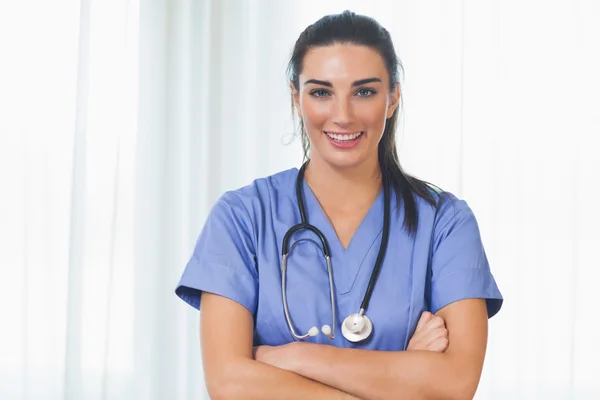 Glad sjuksköterska med armarna korsade — Stockfoto