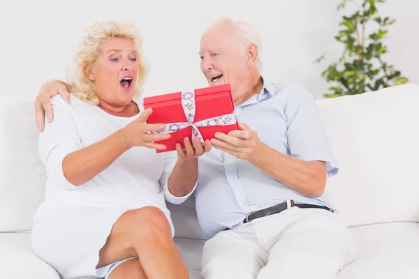 Överraskande gammal kvinna tar emot en gåva — Stockfoto