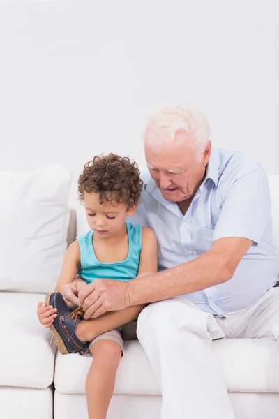 Grandson tying his shoelaces with his grandfather — Stock Photo, Image