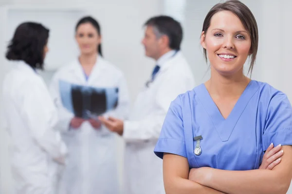 Verpleegkundige lachend met haar team x-ray serieus — Stockfoto