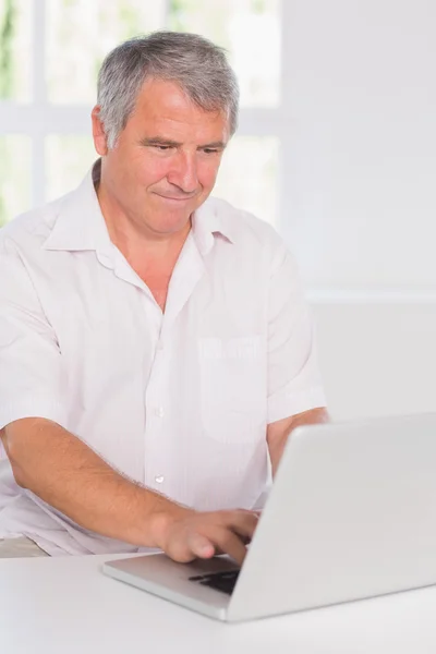 Starý muž soustředění před jeho laptop — Stock fotografie