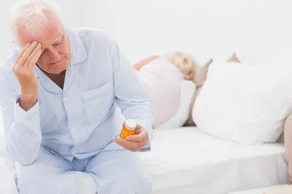 Old man looking at pills — Stock Photo, Image