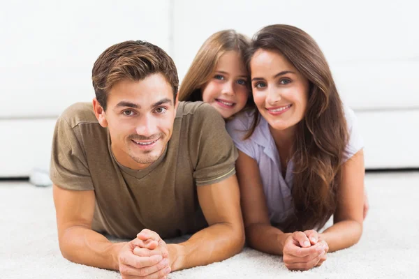 Família posando deitada em um tapete — Fotografia de Stock