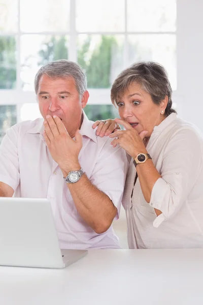 Vieux couple choqué devant un ordinateur portable — Photo