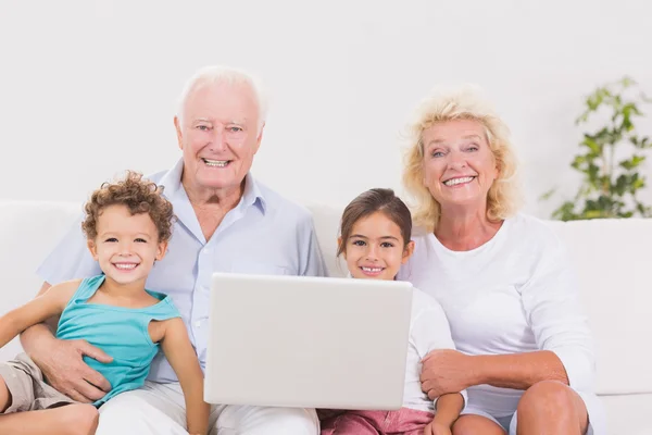 Smiling grandparents with children using a pc — Stock Photo, Image