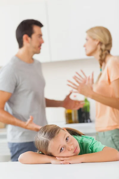 Ouders ruzie achter een triest meisje — Stockfoto