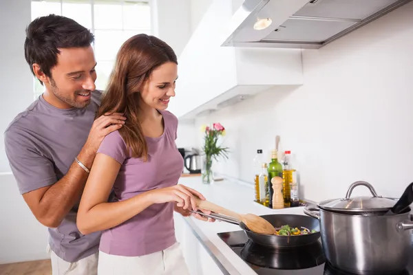 Женщина готовит ужин с партнером смотреть — стоковое фото