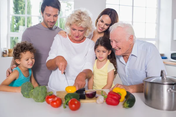 Família feliz cortando legumes juntos — Fotografia de Stock