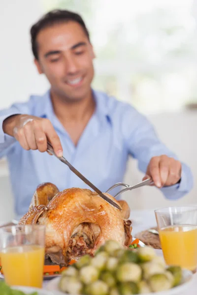 Man carving turkey at head of table — Stock Photo, Image