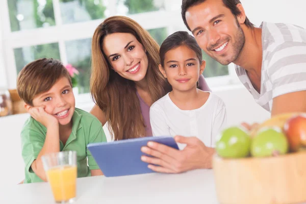 Een tablet pc gebruikt en gelukkige familie — Stockfoto