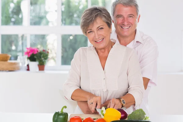 Femme souriante coupant des légumes — Photo