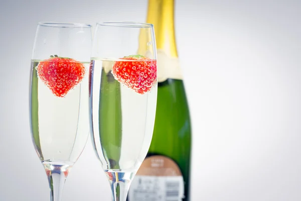 Dwa flety szampana z floating truskawkami — Zdjęcie stockowe
